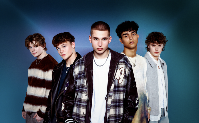 5 boys standing in front of a dark blue background.
